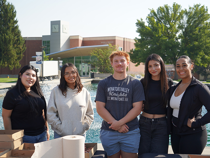Five WVC students standing outside by the fountain with Brown library in the background.