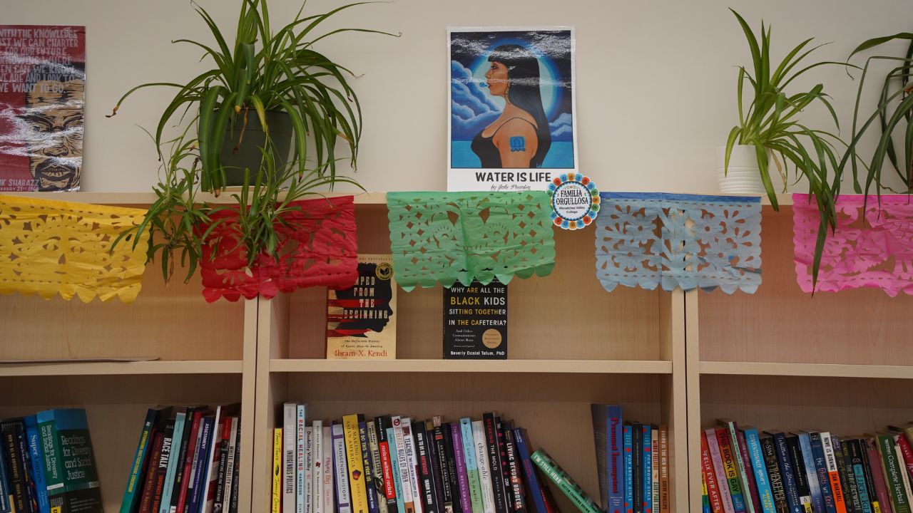 Bookshelf in El Corazón space showing books and papel picadoand