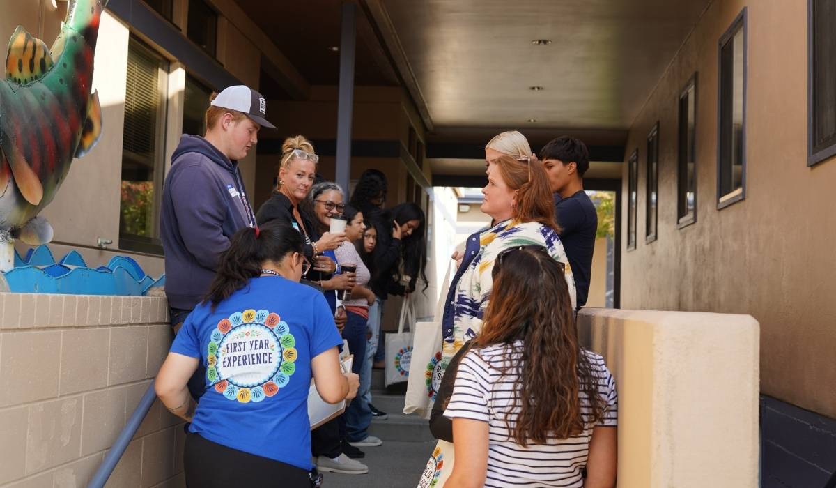 Students gathering with staff near the stairs next to the WVC Omak administrative services building