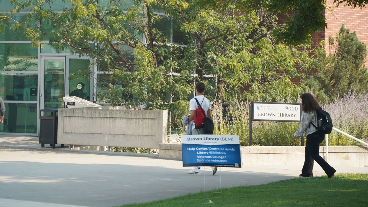 Outside of Brown Library on Wenatchee campus with wayfinding sign in grass nearby