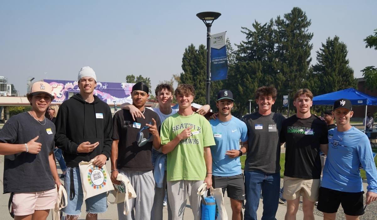 Group of WVC student athletes posing near fountain on Wenatchee Campus