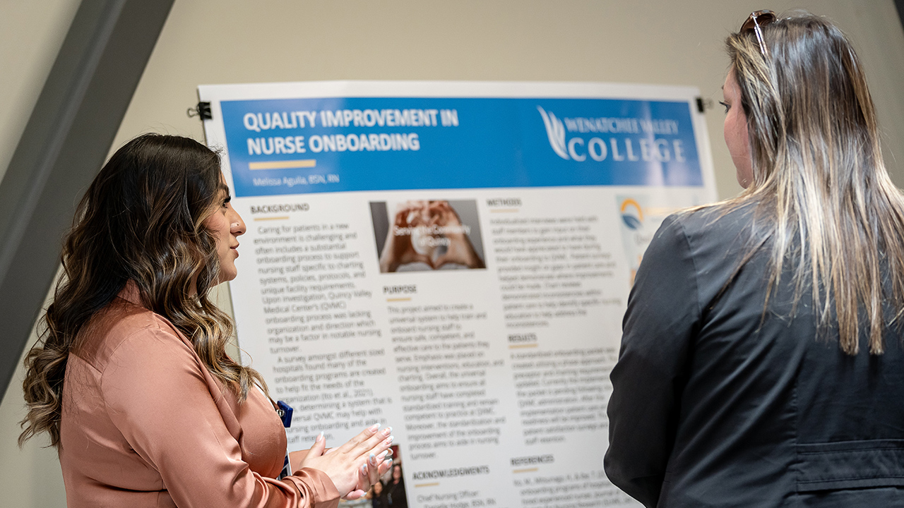 A WVC nursing graduate talks with another person about her RN to BSN research project.