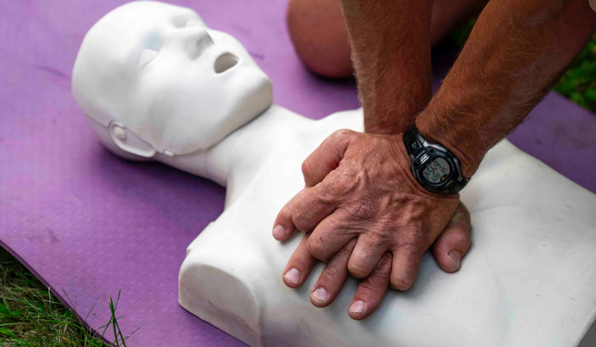 A person performs CPR on a manikin.