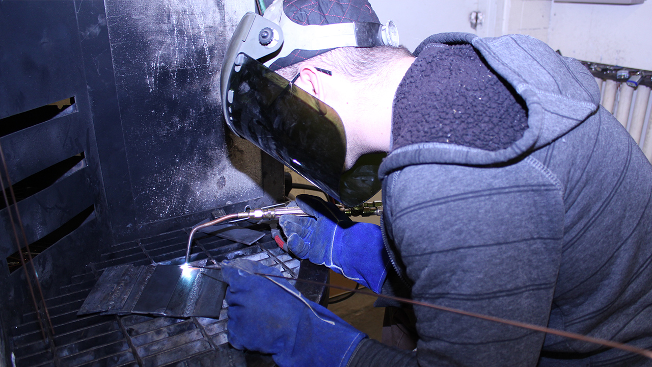 A student performs TIG welding.