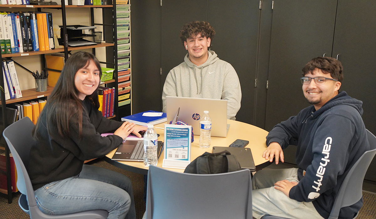Three students sit around a table at WVC's STEM Center.