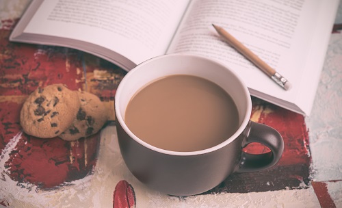 Image of a hot beverage, cookies, and notebook